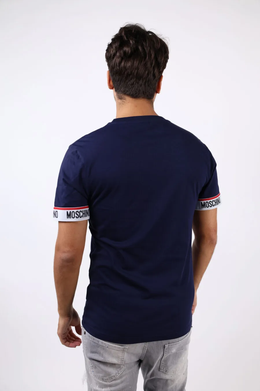 Camiseta azul con logo y línea roja en mangas